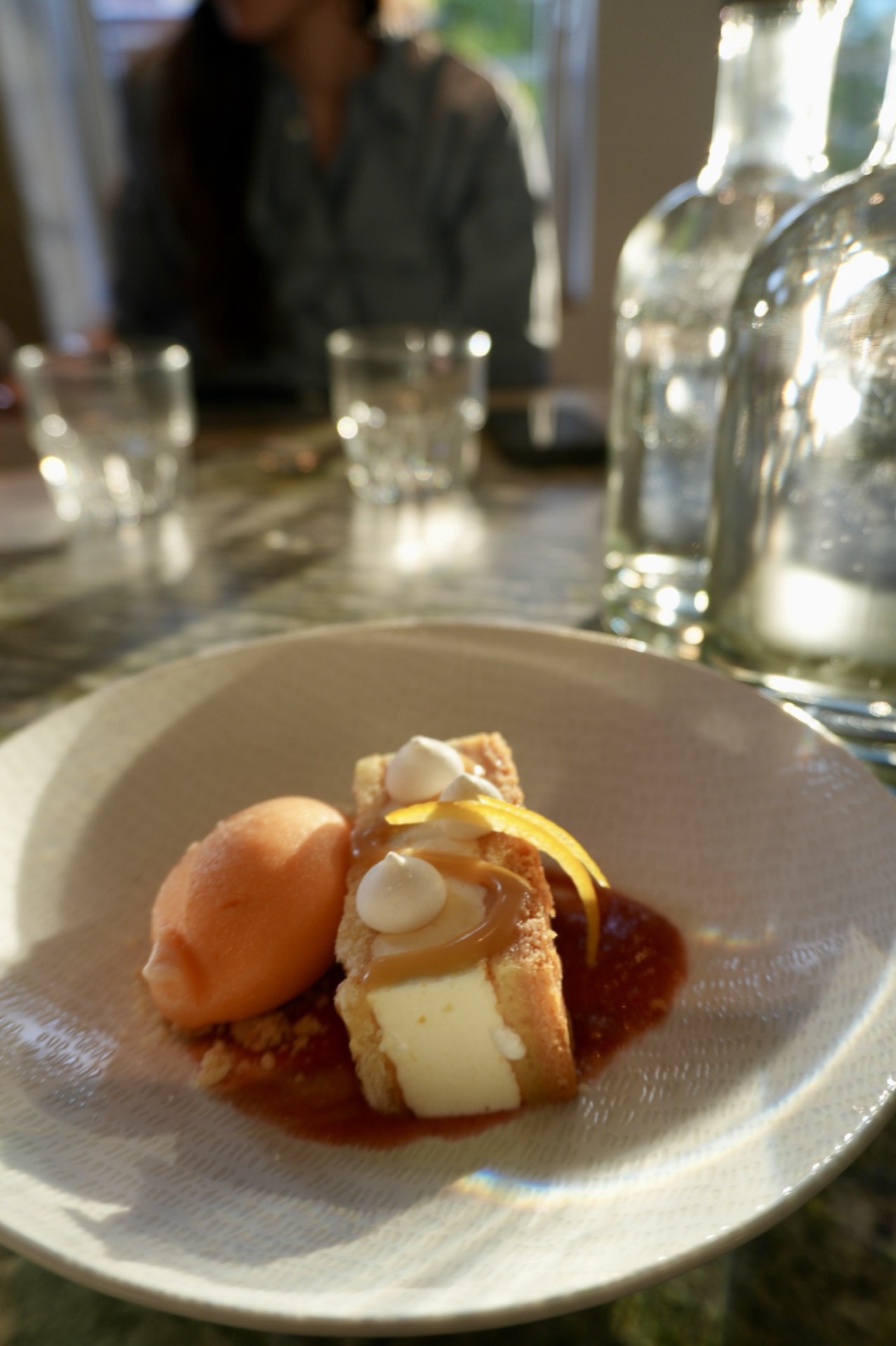 Dessert: lemon meringue with orange sorbet, in golden light